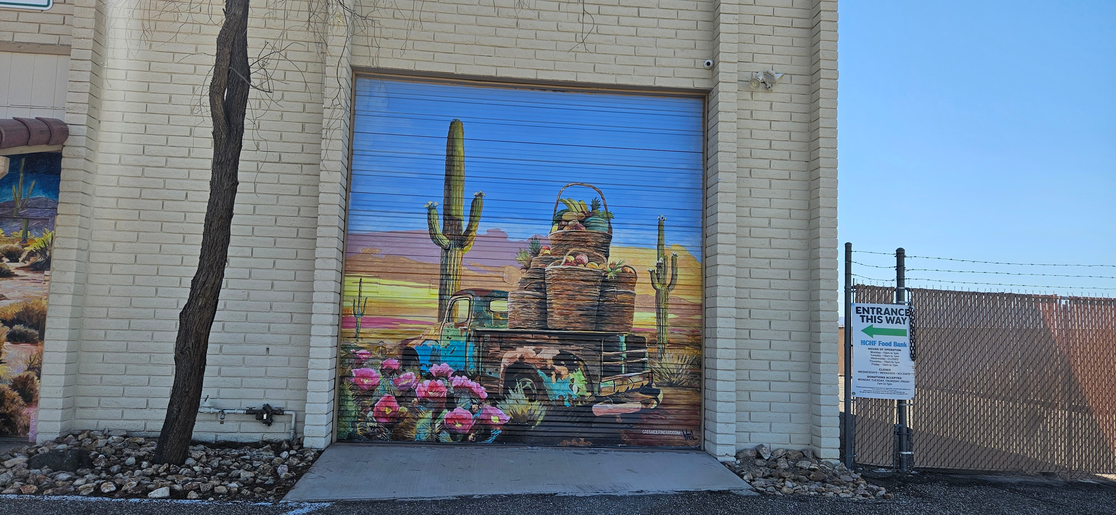 Food bank garage door mural showing a desert landscape, truck, and baskets of produce