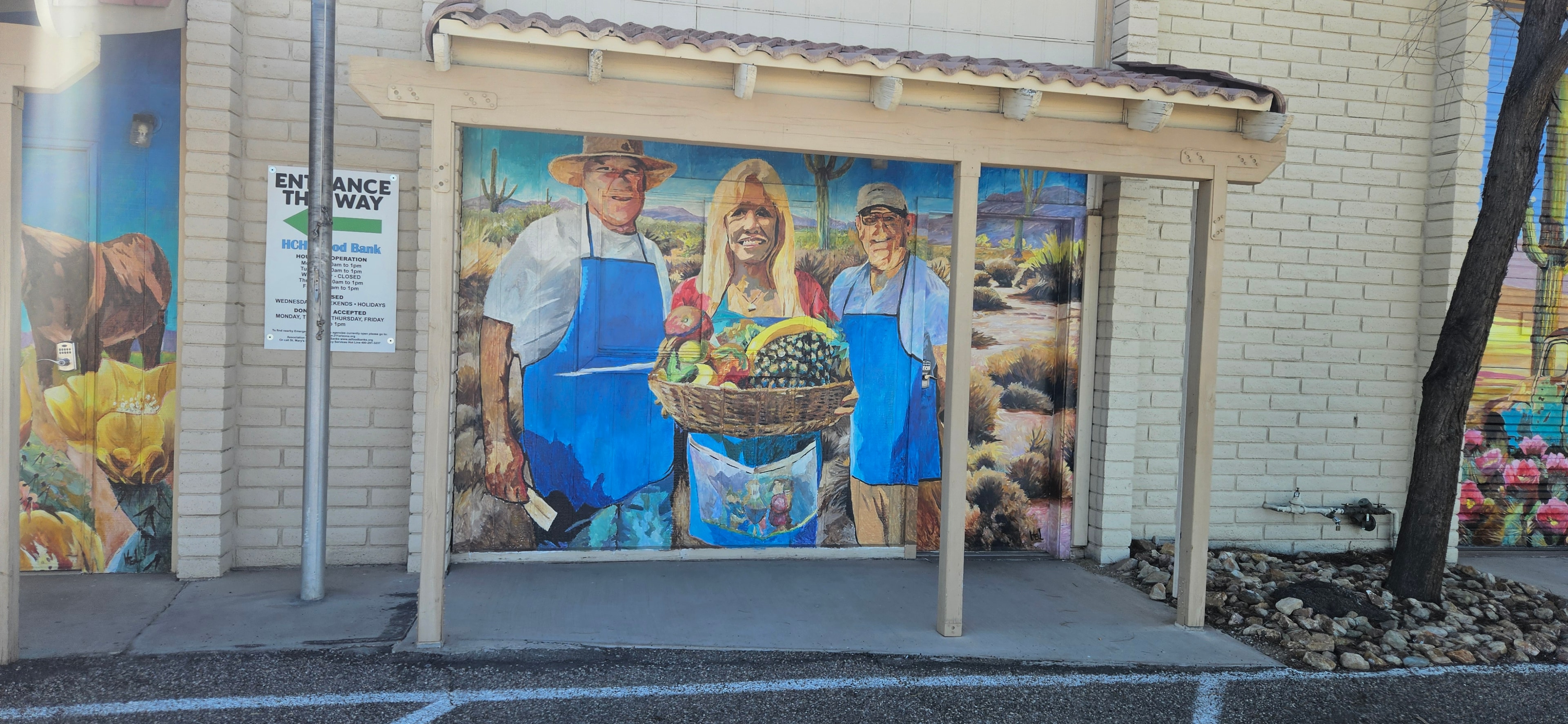 Food bank mural showing volunteers holding a basket of fresh food